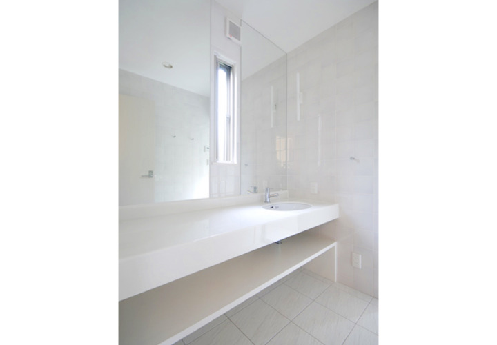 光沢のある白でまとめた洗面室