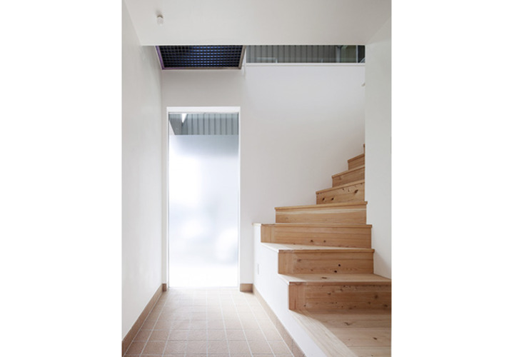 明るいエントランスから緩やかに2階に誘導する階段