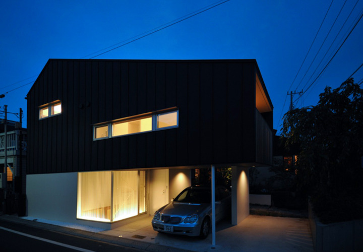 家の灯りと黒壁のコントラストが美しい夜の外観