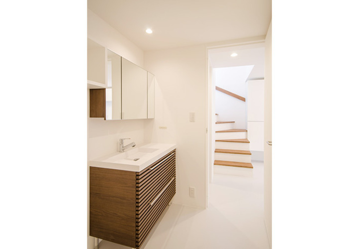 白い壁と調和した木目の洗面