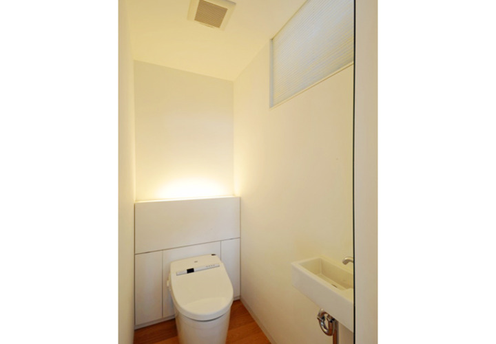 タンクレストイレの背面には扉付の収納を配置