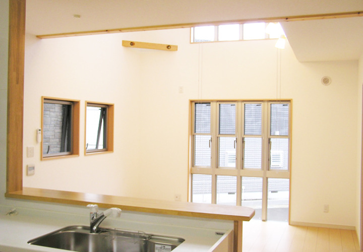 キッチンから吹き抜けのリビングを眺める