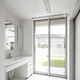 中庭を見ながら身支度ができる、明るく開放的な白一色の洗面脱衣室