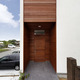 庇代わりに外壁からセットバックさせて玄関ドアを作った、木目の美しい玄関