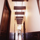 吹き抜け空間に梁をデザインに盛り込んだ、腰壁のある奥行きのある廊下