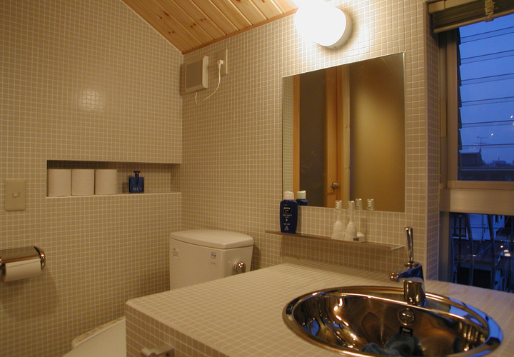 床壁だけでなく洗面台もモザイクタイルでスマートな印象のトイレスペース