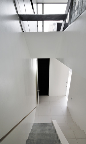 美しい白の床壁と、素材そのものが活かされた階段が新鮮な玄関ホール