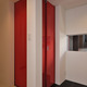 白と黒のタイルの床材に、この家のシンボルカラーの赤色の扉が個性的な玄関ホール