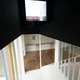 真っ黒の２階中壁と白く軽やかな１階スペースが、視覚的に楽しめる階段スペース