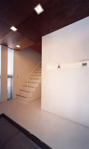 天井に木を使用し、白い空間をシックな雰囲気に仕上げた広さのある玄関ホール