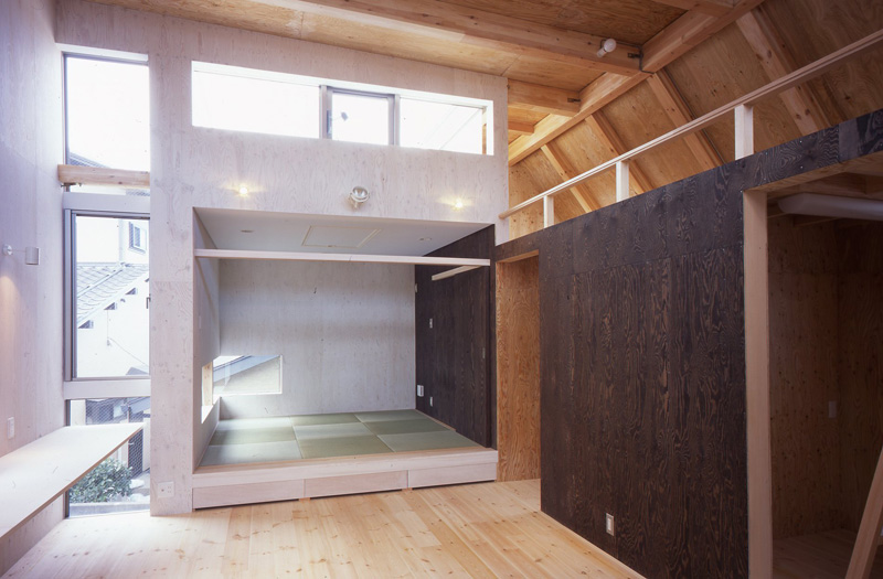 ナチュラルな木目の空間にアクセントとなるダークな色合いの壁