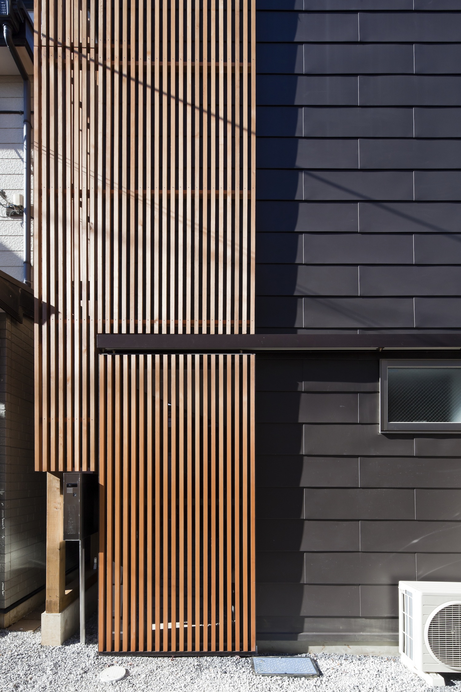 外壁と木の格子の組み合わせが印象的なファサード