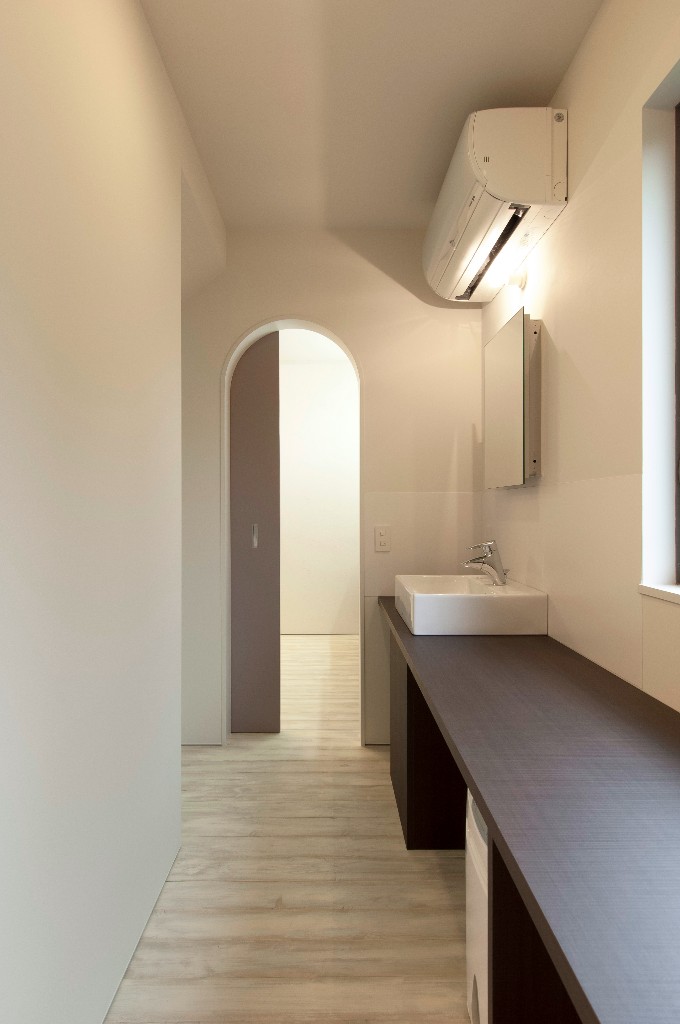 直線的なデザインのパウダールームにカーブが柔らかく美しいアーチの入り口