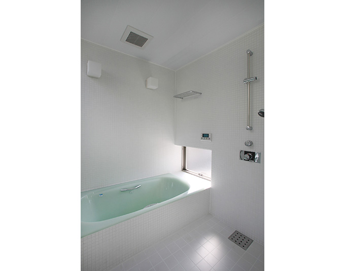 白いタイル張りの爽やかなバスルーム