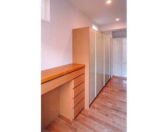 キッチン裏に並ぶ淡いグリーンの収納棚