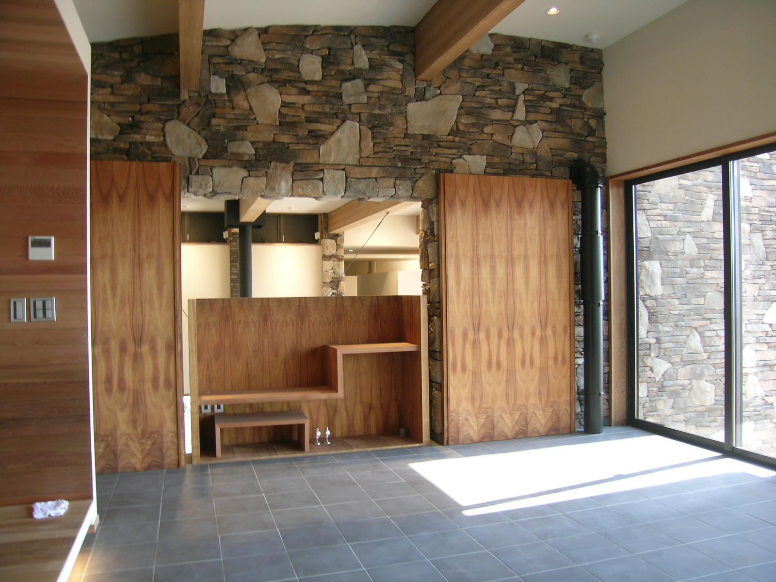 木目が美しい扉を開けると吹き抜けのリビングに繋がる