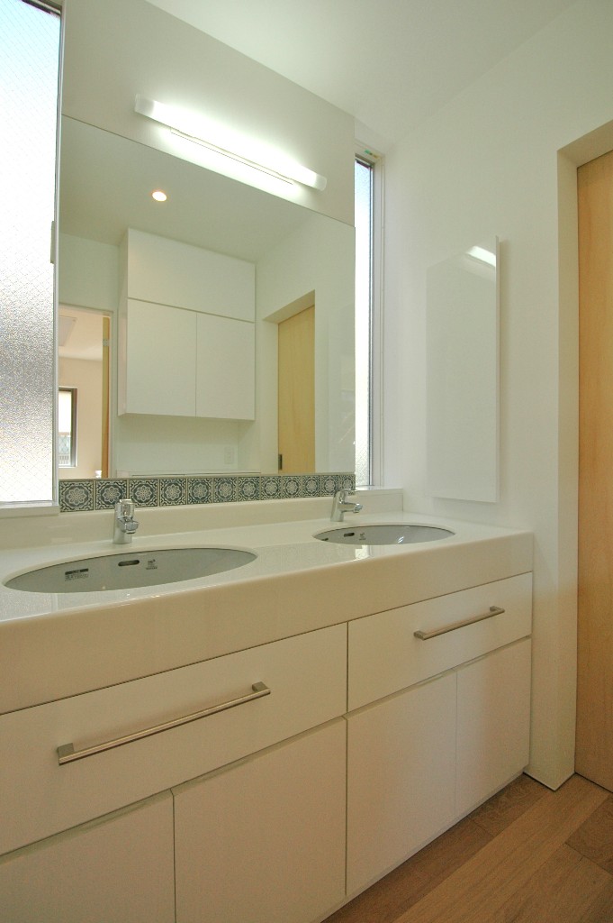 スリット窓からさわやかな陽が射し込むダブルボウルの洗面スペース