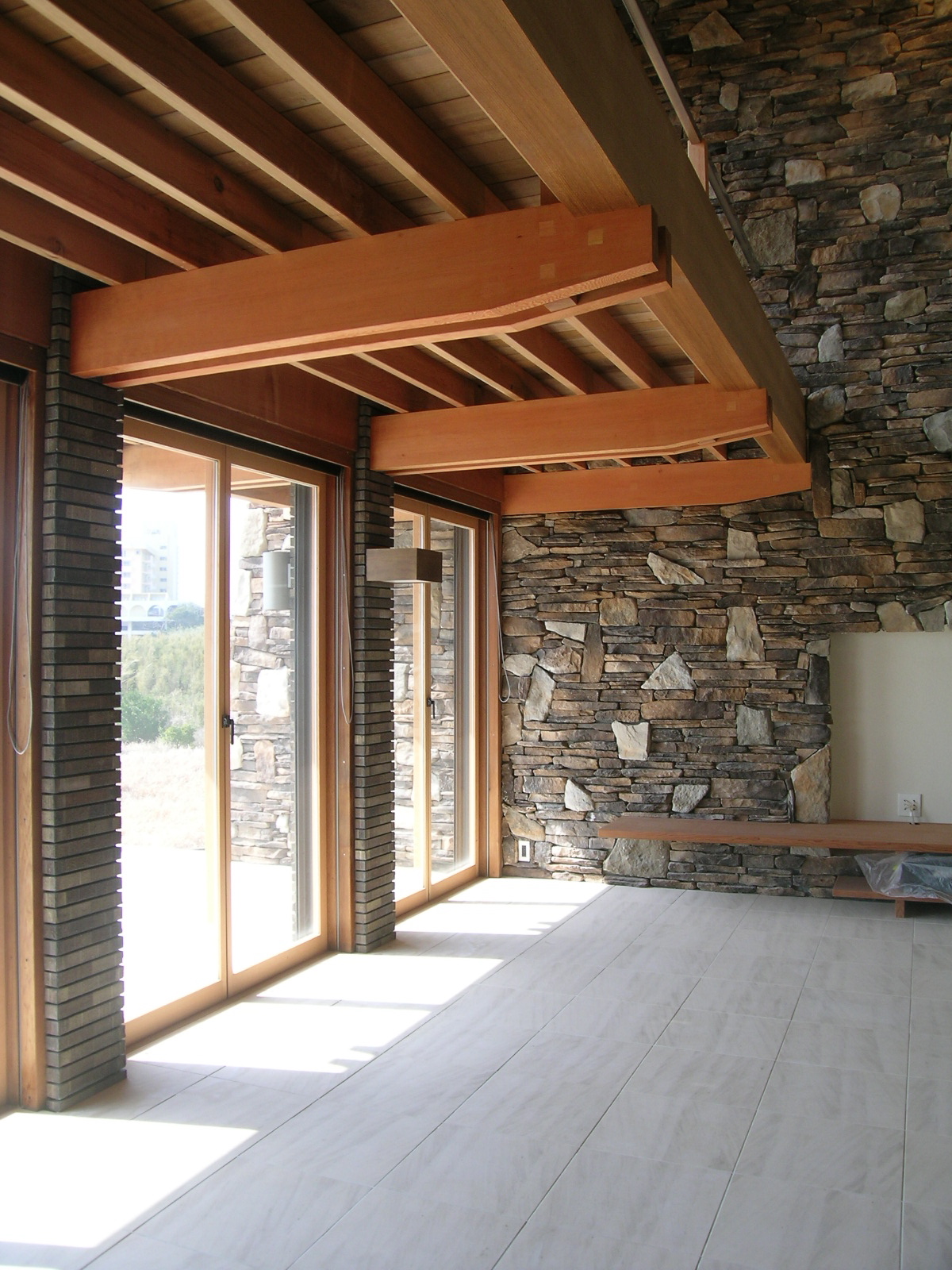 建物の外側まで石張りの壁が続き屋外と一体化したような雰囲気の室内