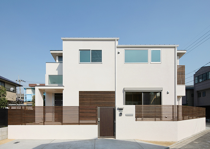 シンプルな白壁に木柵が映える外観