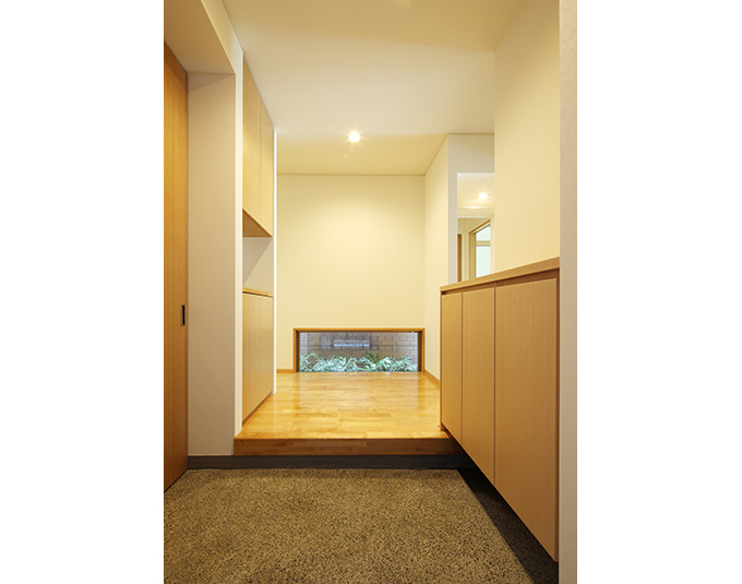 地窓からのぞく緑が迎える玄関ホール