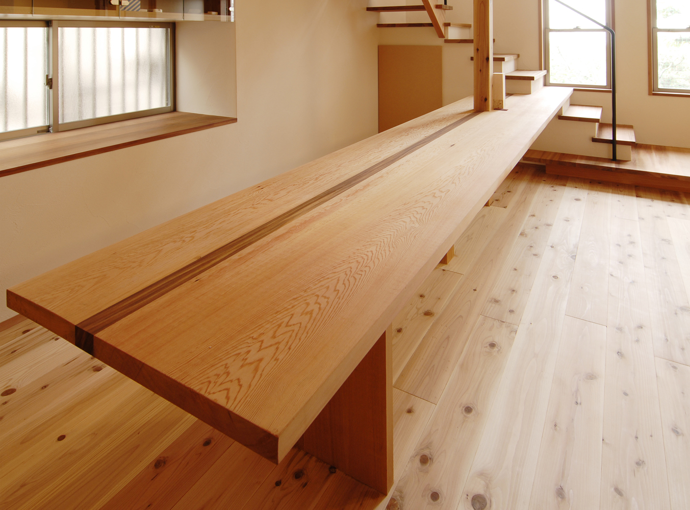 階段から続く造り付け一枚板のユニークなダイニングテーブル