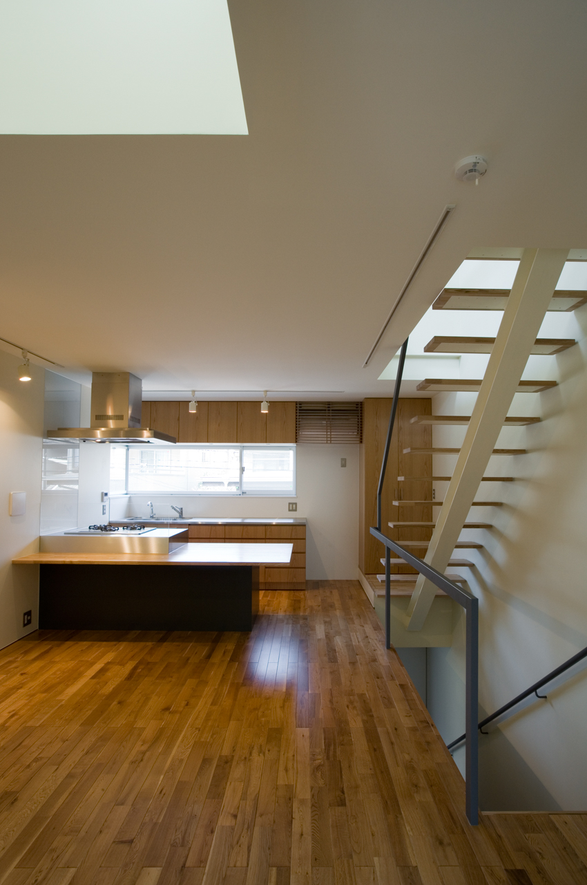 白い空間に床とキッチンの木目が映えるリビングダイニングキッチン