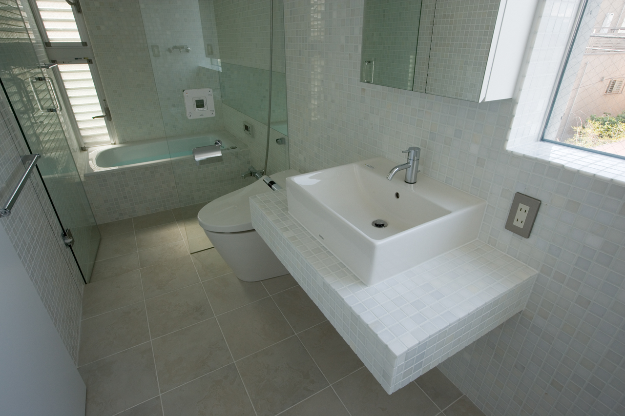 ニュアンスのあるタイル張りが白い空間にアクセントとなり落ち着いた雰囲気のバスルーム