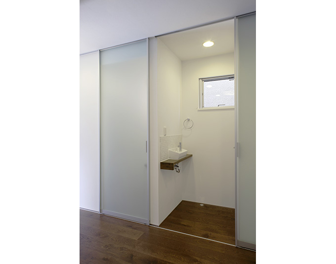 摺りガラスの引戸隠せる水廻り