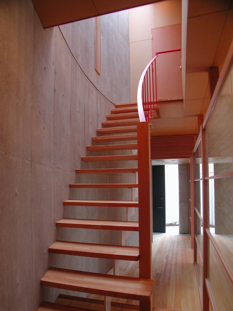 明るい光が差し込む暖かい色調の階段ホール