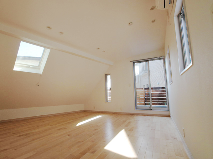 傾斜屋根の天窓から空を眺める