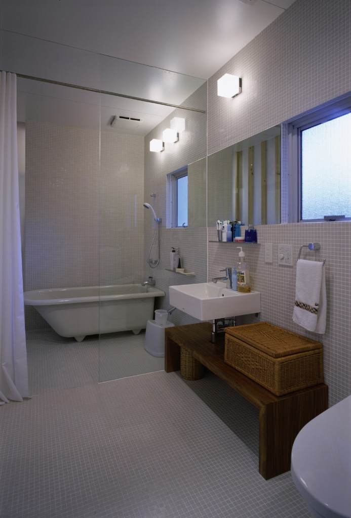 薄いグレーの床壁に白い洗面台や置き浴槽が素敵なバスルーム