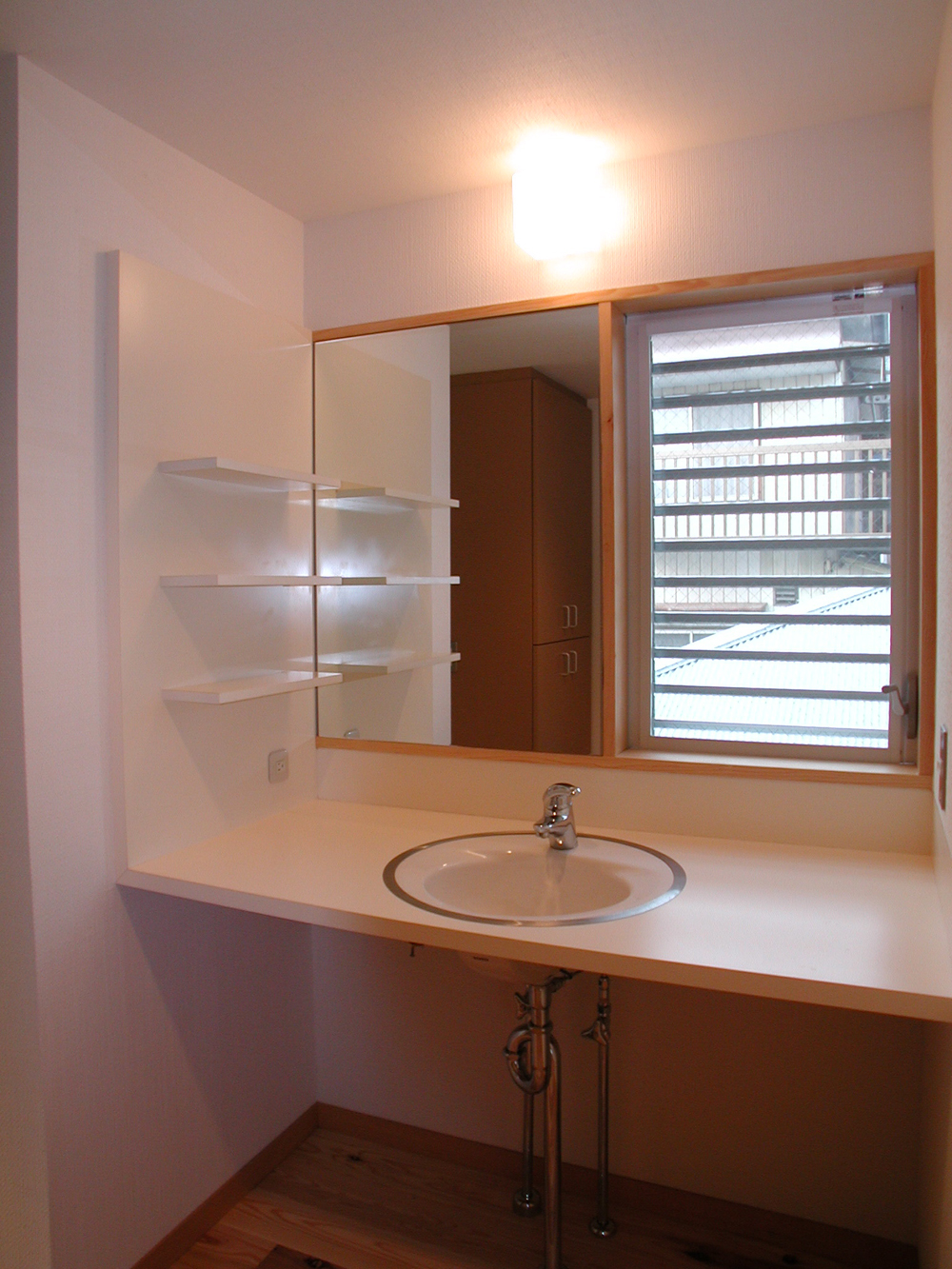 直線的なデザインに丸い洗面ボウルがアクセントのシンプルな洗面スペース