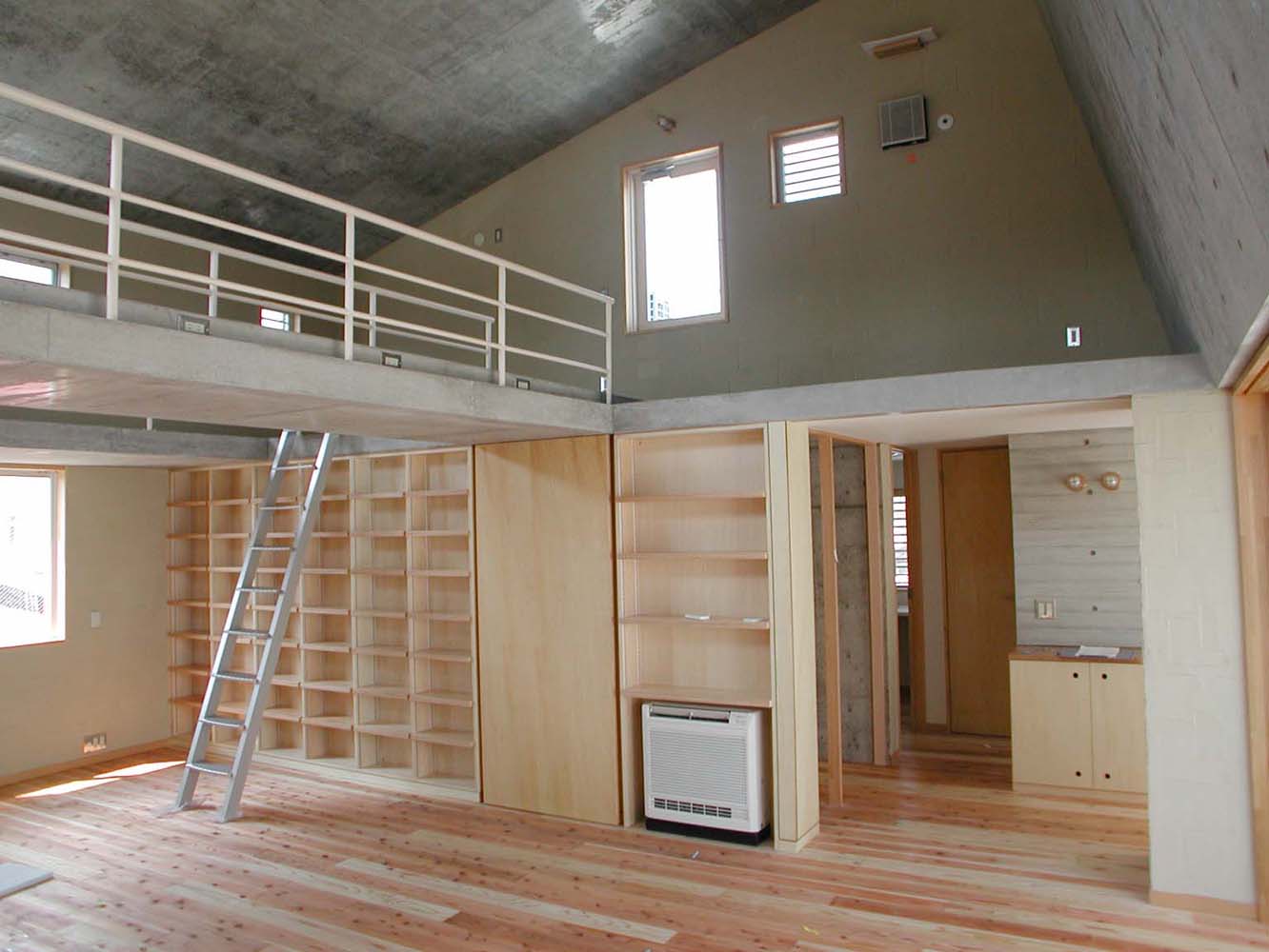 無機質なコンクリート打ち放しに杉フローリングと中霧島壁がナチュラルな印象に