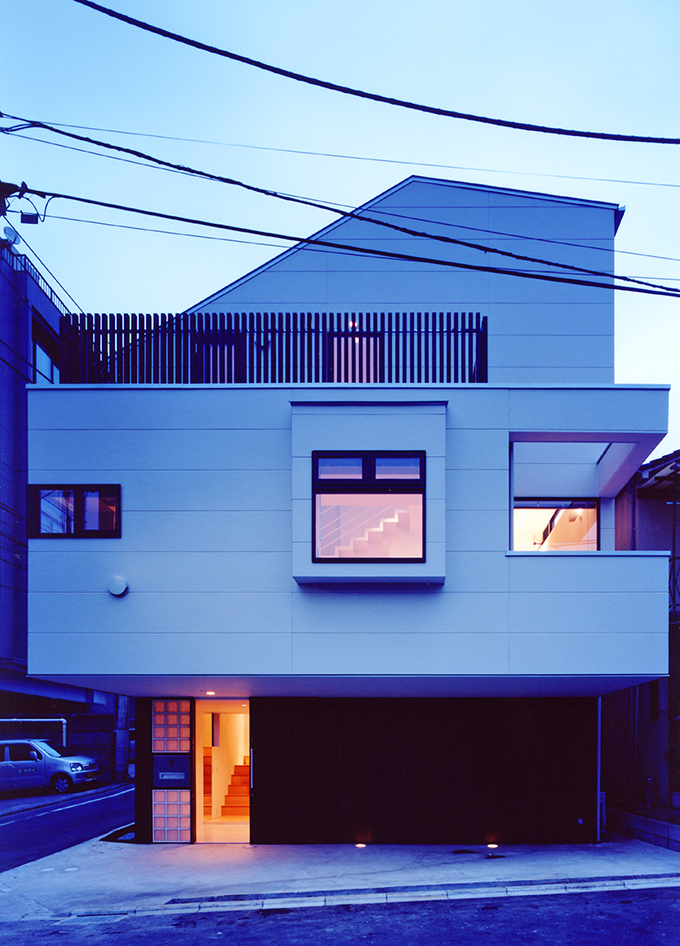 小窓から吹き抜け階段がのぞく夕景外観