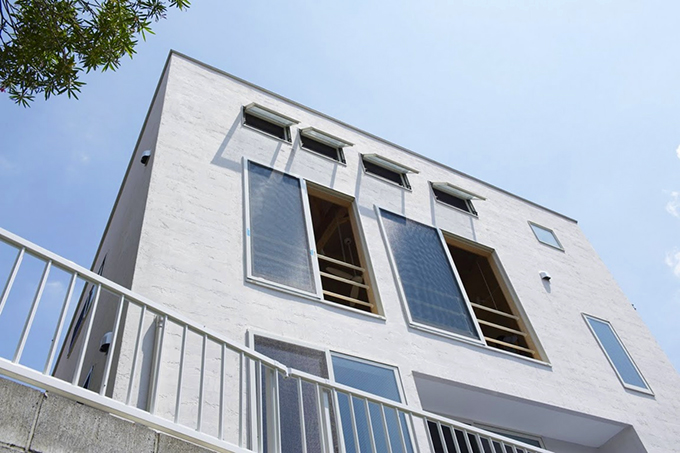小窓が並ぶ白壁のファサード
