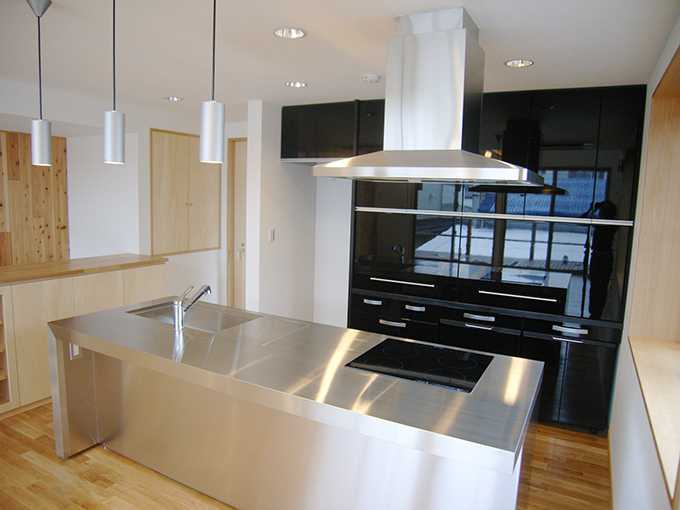 空間を引き締めるシックなオープンキッチン