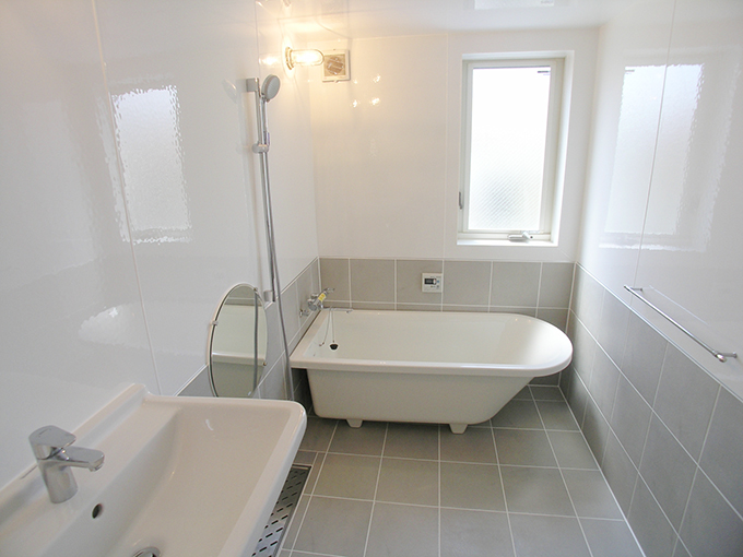 丸い鏡が印象的な浴室