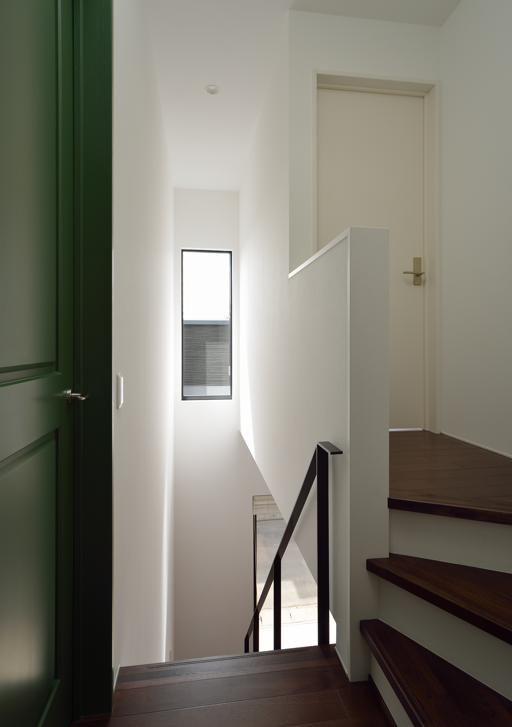 白、緑、焦げ茶のカラーバランスが絶妙な吹抜けの階段