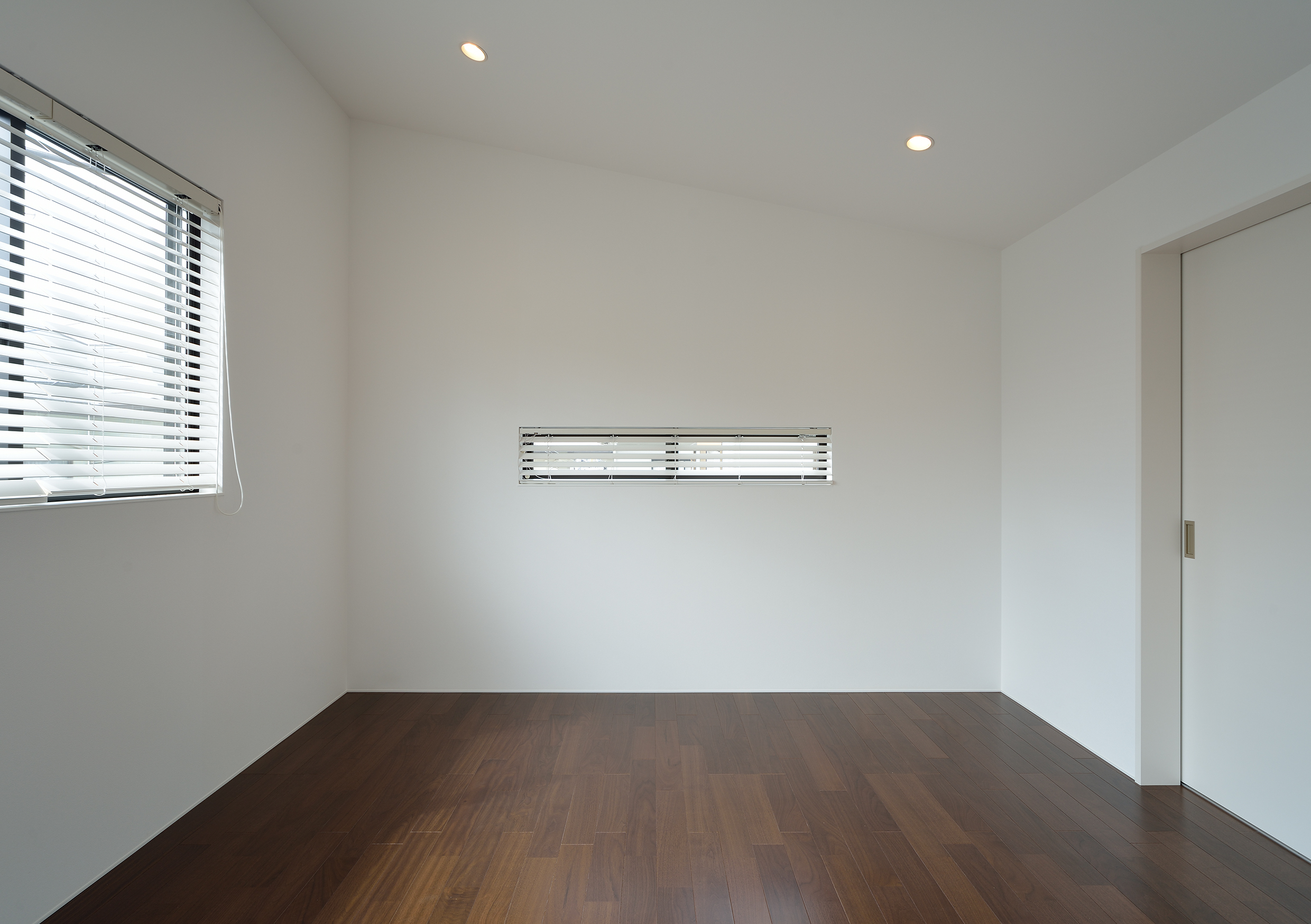 広がりのある勾配天井のシンプルな寝室