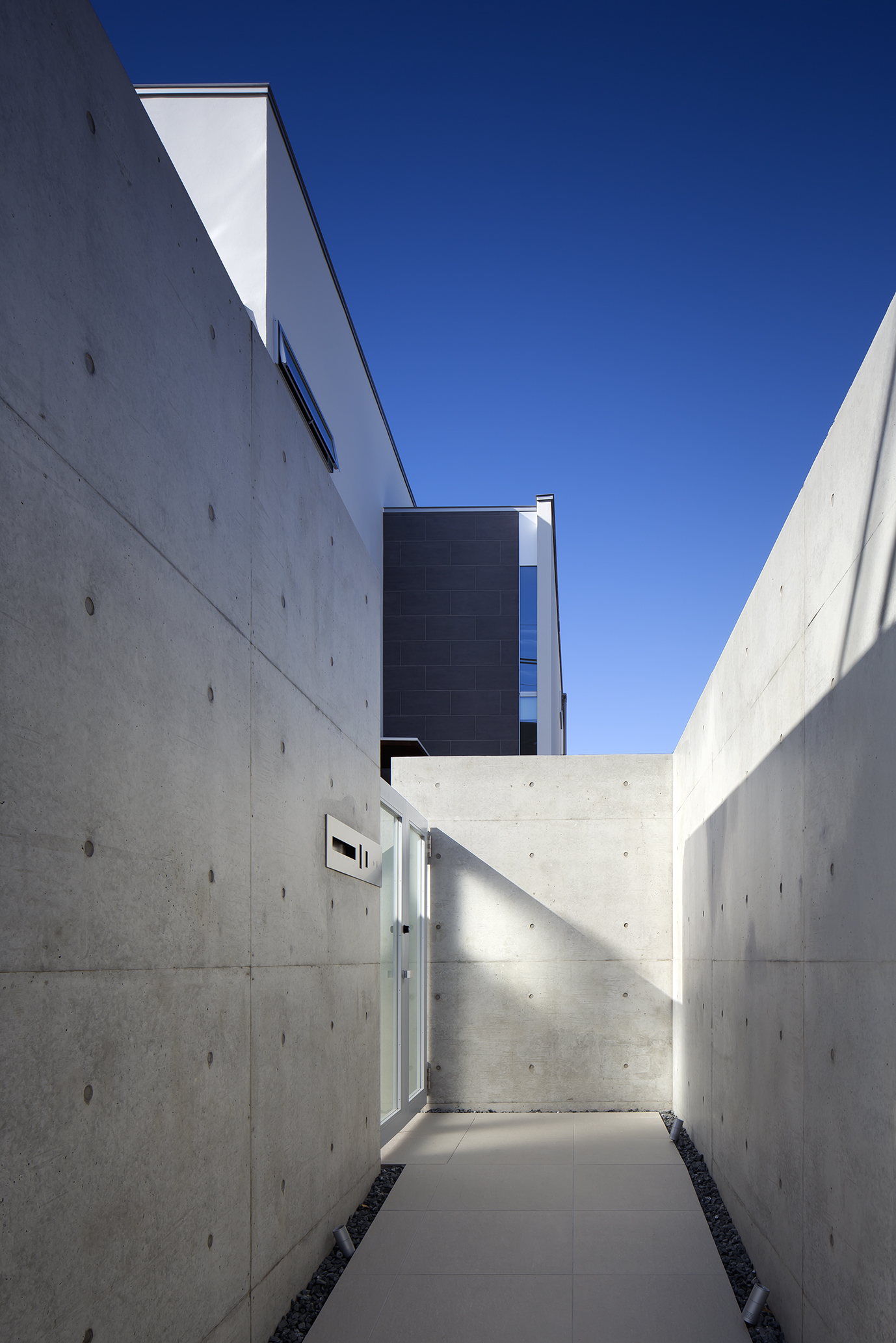 ＲＣ打ちっ放し塀に囲まれた、重厚感のあるアプローチ