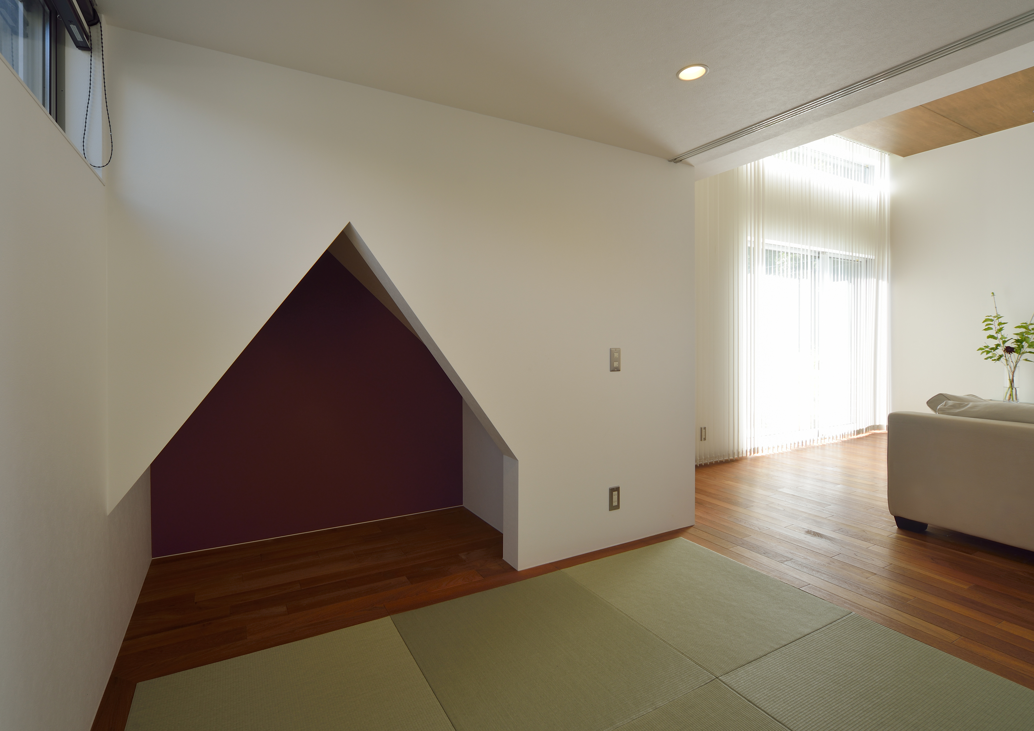 切り妻屋根型に抜けた、遊び心のある壁が印象的な和室