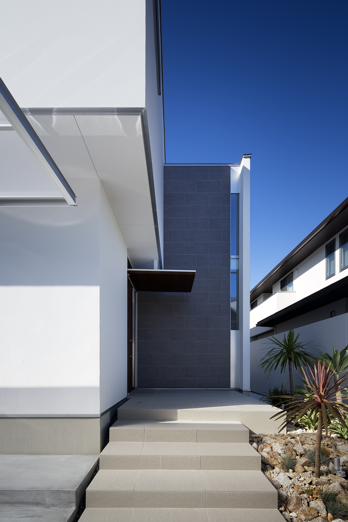 南国風な植栽が、その緊張感を和らげてくれる玄関ポーチ