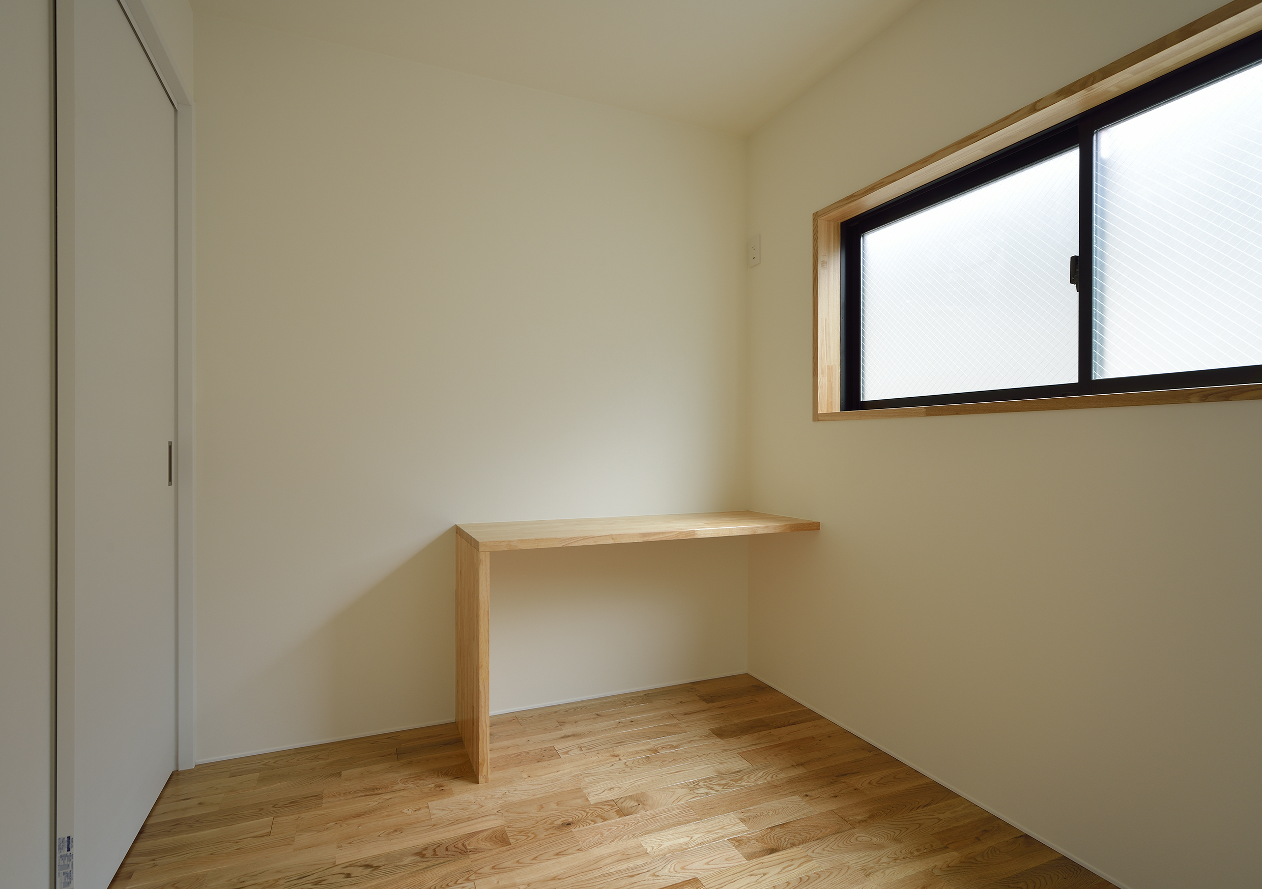 造作物のワークデスクがシンプルな部屋に合う寝室