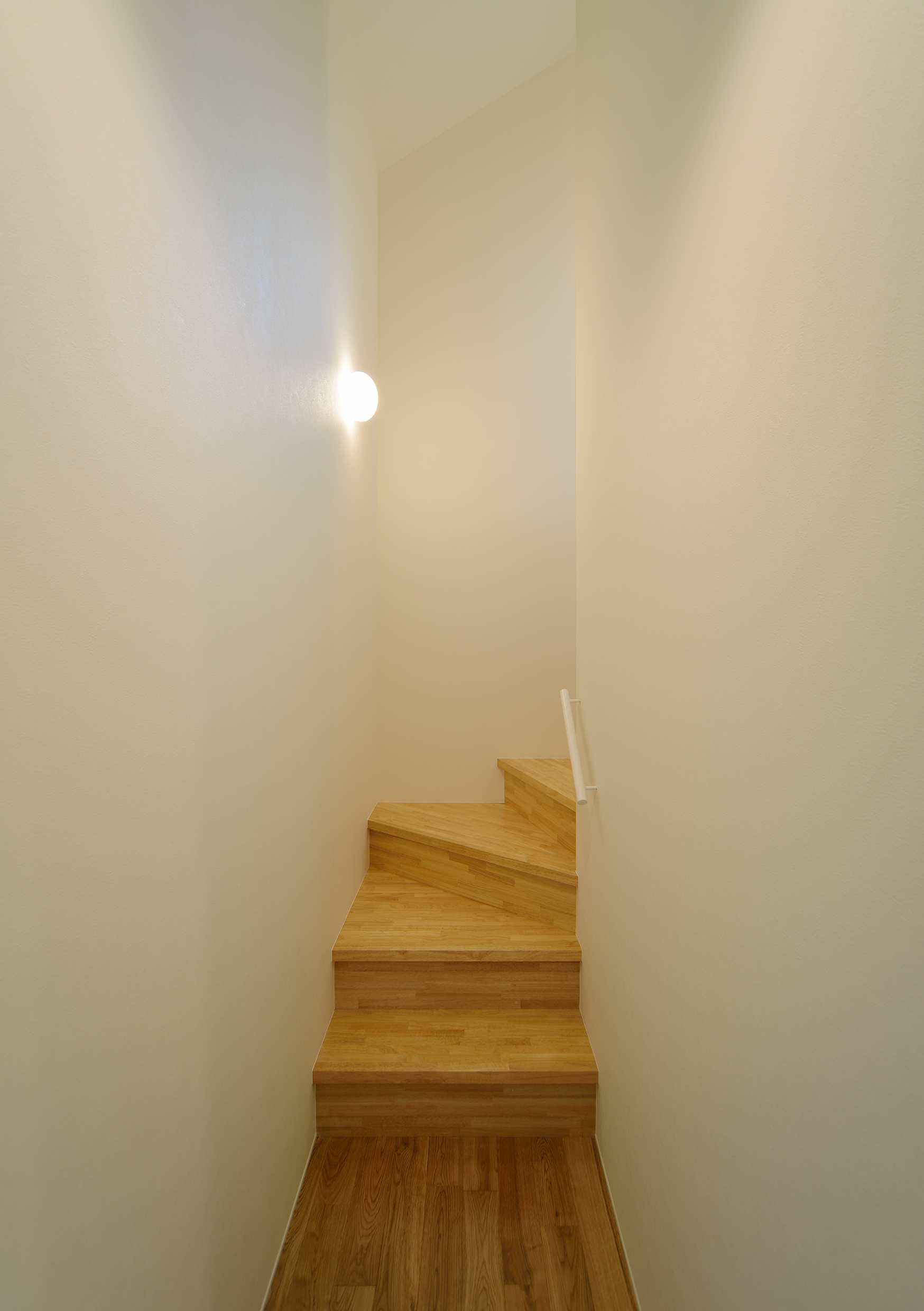 集成材の木調が白い壁と共に若々しさを感じる階段