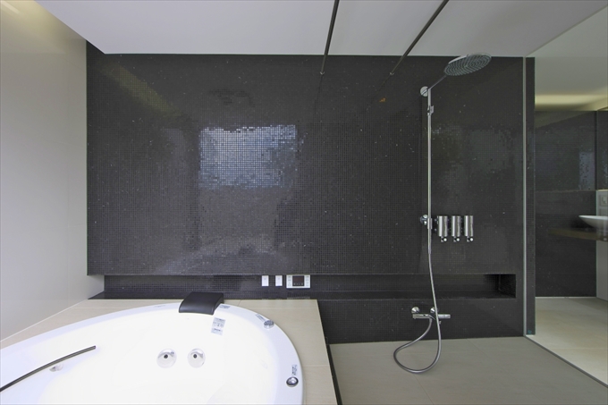 黒いタイルが印象的な浴室