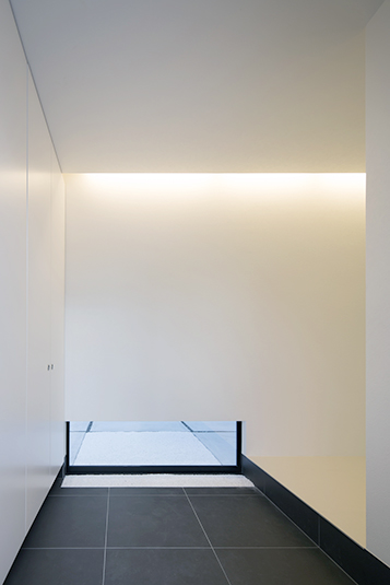 ローサイドライトが外の気配を感じさせる玄関