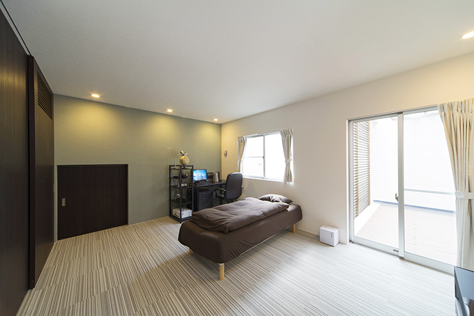 薄いグリーンの壁が落ち着きを放つ寝室