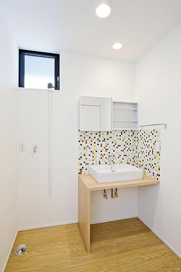 白壁にモザイクタイルが印象的な洗面台