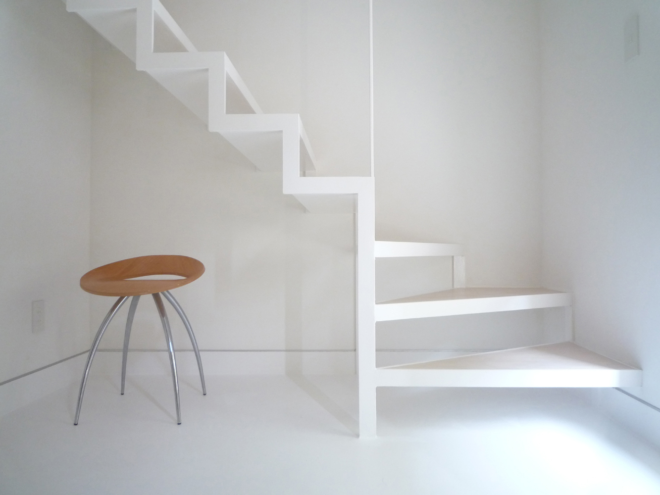 白でまとめあげた、軽やかで動きのあるフレーム階段