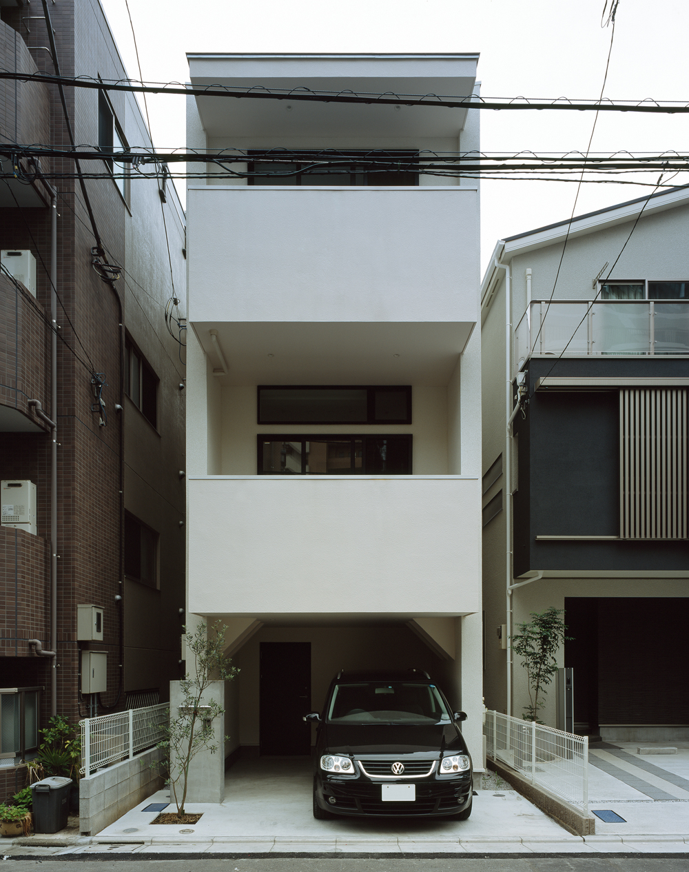 中高層マンションの建ち並ぶ中で、採光と目線を切ることに配慮した外観